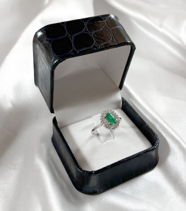 Anillo de oro blanco con diamantes y una esmeralda central