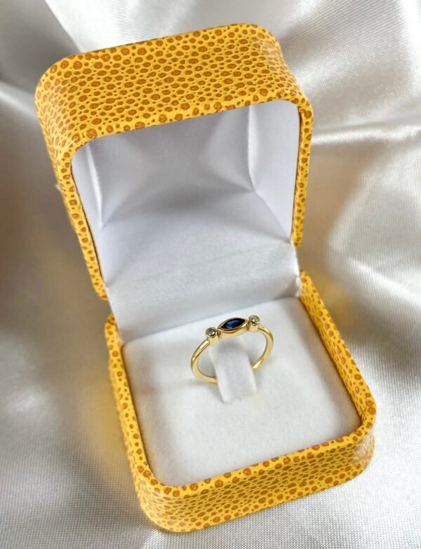 Anillo de oro amarillo con 2 diamantes y 1 zafiro ovalado central
